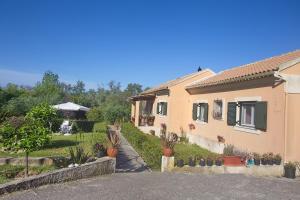 a house with a yard with potted plants at Eleni's House by Corfuescapes in Corfu