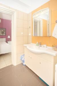 a bathroom with a sink and a mirror at Eleni's House by Corfuescapes in Corfu +31 photos