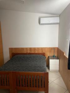 um quarto com uma cama de madeira e uma parede branca em Riccardo’s house em Casale Malnome