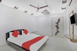 1 dormitorio con 1 cama y TV en la pared en Flagship Hotel Rudra Palace en Ahmedabad