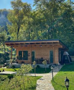 a log cabin with a tent in a yard at Mon Resort by Ana1St in Scărişoara