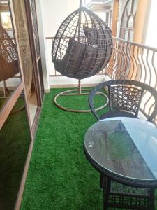 a table and chairs on a balcony with green grass at Elegant furnished rooms with swimming pool in Nyali in Mombasa