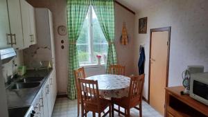 a kitchen with a table and chairs and a window at Förvaltarbostaden in Åtvidaberg