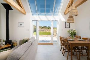 a living room with a couch and a table at Meadow View Barn, Rural St Ives, Cornwall. Brand New 2 Bedroom Idyllic Contemporary Cottage With Log Burner. in Nancledra