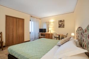 a hotel room with a bed and a desk at Relais La Fattoria in Castel Rigone