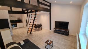 sala de estar con sofá, TV y escalera en Dream Apartments 3B KLIMATYZACJA, en Oświęcim