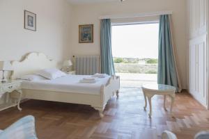 una camera da letto con un letto, una scrivania e una finestra di Pelion's Finest Estate a Káto Lekhónia Altre 34 foto