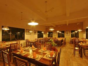 a dining room with wooden tables and chairs at Gir Birding Lodge in Sasan Gir