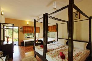 a bedroom with two beds and a desk at Gir Birding Lodge in Sasan Gir