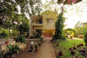 a house with a garden with potted plants at Gir Birding Lodge in Sasan Gir
