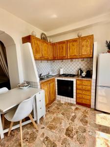 a kitchen with wooden cabinets and a white refrigerator at Capri Joy in Capri