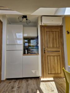 a kitchen with a refrigerator and a door at LIGHTHOUSE - Adults Only - 12Plus in Krynica Morska