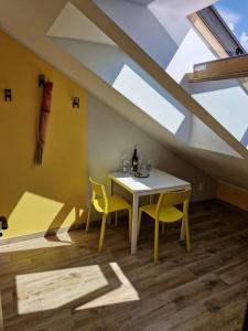 a dining room with a table and two yellow chairs at LIGHTHOUSE - Adults Only - 12Plus in Krynica Morska