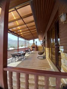 een balkon van een huis met tafels en stoelen bij Come & Rest in Kazbegi