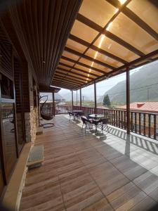 a wooden deck with tables and chairs on a balcony at Come & Rest in Stepantsminda