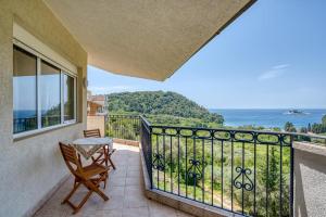 a balcony with a table and chairs and the ocean at The view villa in Petrovac na Moru