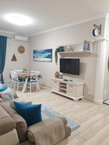 a living room with a couch and a tv at Luxury Beach House in Torvaianica