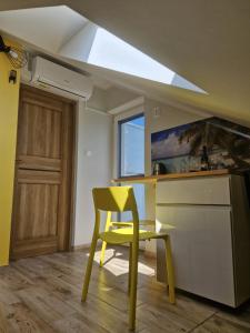 a yellow chair in a kitchen with a window at LIGHTHOUSE - Adults Only - 12Plus in Krynica Morska