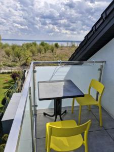 a balcony with a table and two yellow chairs at LIGHTHOUSE - Adults Only - 12Plus in Krynica Morska
