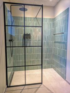 a shower with a glass door in a bathroom at Cozy apartment in Runavík in Saltangará