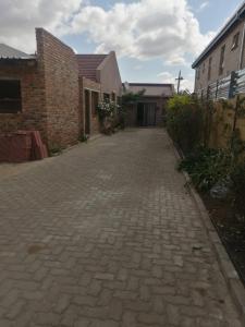 a cobblestone driveway in front of a brick building at Walalawasala in Polokwane