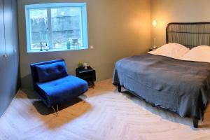 een slaapkamer met een bed en een blauwe stoel bij Cozy apartment in Runavík in Saltangará