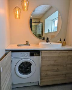 een badkamer met een wasmachine en een spiegel bij Cozy apartment in Runavík in Saltangará