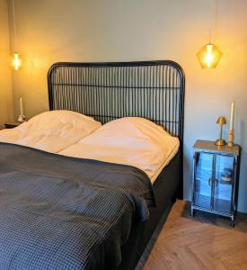 a bed with a metal headboard and a side table at Cozy apartment in Runavík in Saltangará