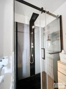 une douche avec une brosse à dents accrochée au mur dans l'établissement Le Maeva -Vue Mer 3e Étage, à Bray-Dunes 6 autres photos