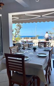 a table with chairs and a table with a view of the ocean at Hotel Kolagji in Himare