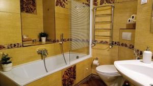 a bathroom with a tub and a toilet and a sink at Atlashouse in Rīga