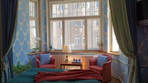 a bedroom with two chairs and a bed and a window at Atlashouse in Rīga