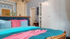 a bedroom with a bed with blue and pink at Atlashouse in Rīga
