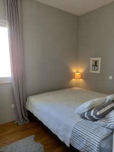 una camera da letto con un letto e una lampada accanto a una finestra di Sea Salt Apartment a Novalja (Novaglia)