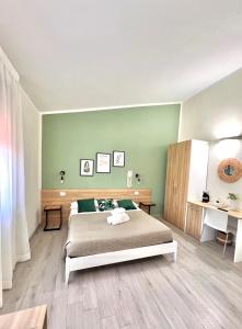 a bedroom with a bed and a green wall at InCentro - San Teodoro in San Teodoro