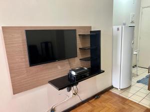 uma televisão de ecrã plano numa parede ao lado de um frigorífico em Complete and quiet apartment @ Copacabana no Rio de Janeiro