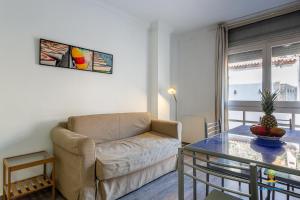 een woonkamer met een bank en een glazen tafel bij Da Paolo Apartment (in front of the beach) in Lloret de Mar