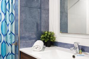 een badkamer met een wastafel en een douche met een spiegel bij Da Paolo Apartment (in front of the beach) in Lloret de Mar