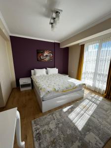 een slaapkamer met een groot bed en een paarse muur bij Seyir Apartmanı in Bolu