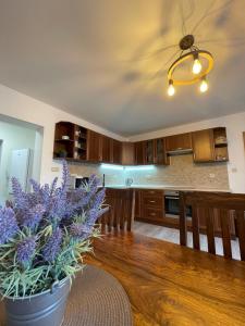 una cucina con un tavolo di legno e un vaso con fiori viola di Apartmán Kameňák a Vimperk