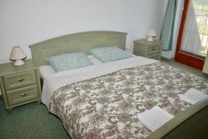 um quarto com uma cama grande e 2 mesas de cabeceira em Éden Panzio em Bük