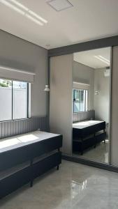 een kamer met 2 bedden en een grote spiegel bij Para dormir, curtir e trabalhar! in Sinop