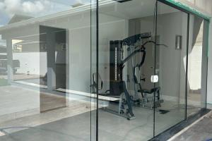 a room with a gym with glass walls at Para dormir, curtir e trabalhar! in Sinop