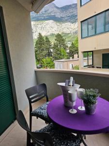 a purple table and chairs on a balcony at Sweet suite in Makarska