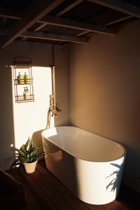 a white bath tub in a bathroom with a window at Byron Hinterland Rustic Off Grid Cabin in Rosebank