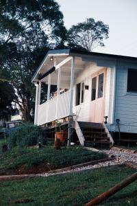a small house with a porch and a front porch at Byron Hinterland Rustic Off Grid Cabin in Rosebank