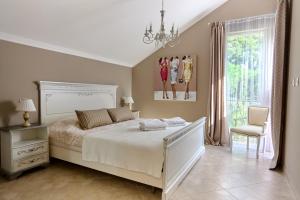 une chambre avec un lit, une chaise et une fenêtre dans l'établissement GH Aparts with SCENIC VIEWS & POOL, à Gornji Orahovac