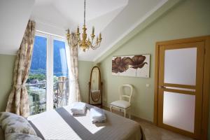 une chambre avec un lit et une grande fenêtre dans l'établissement GH Aparts with SCENIC VIEWS & POOL, à Gornji Orahovac