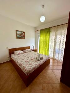 a bedroom with a bed and a green curtain at Apartment Ermest ,Kavaje Rock in Durrës +32 photos