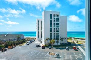 a large white building with a parking lot and the ocean at Shoreline Towers 3063 in Destin